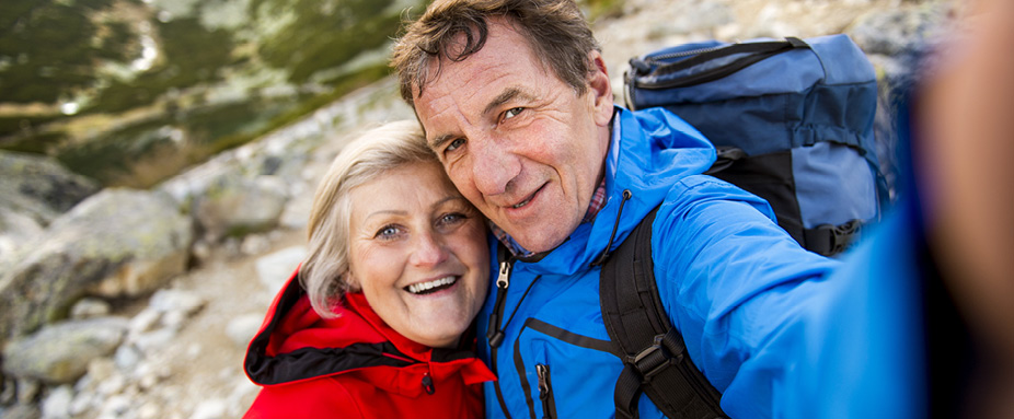Senioren beim Wandern machen Selfie - Unfallversicherung Senioren